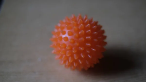a gymnastic ball with spikes lies on the table and gives shadows