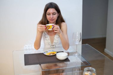 Ballerina drinking tea at a glass table