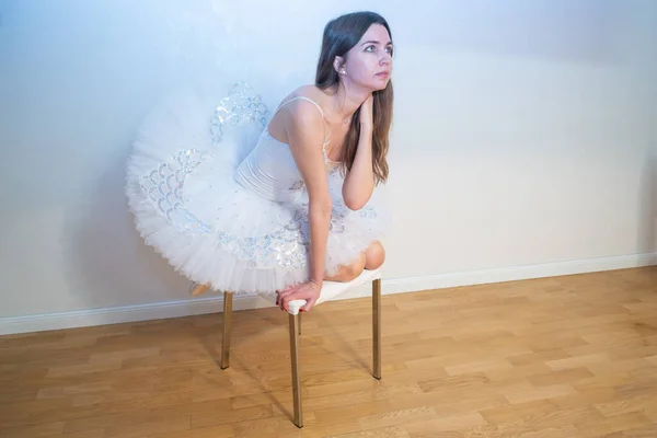 身着白色燕尾服的芭蕾舞女坐在椅子上 — 图库照片
