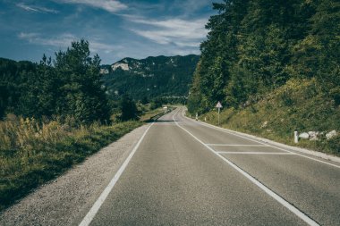 Dağlar ve çayırlar arasında bir yolu olan manzara