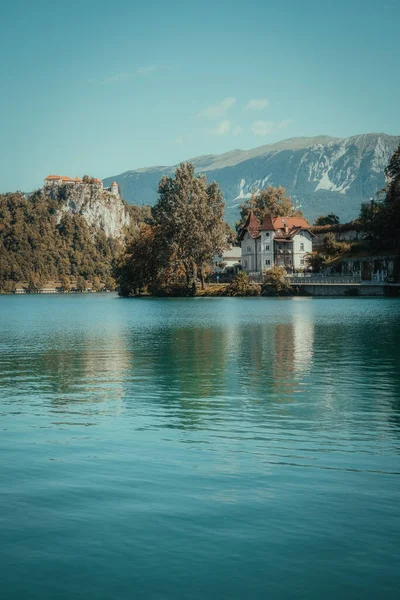 Dağlarla ve evlerle çevrili bir göl manzarası