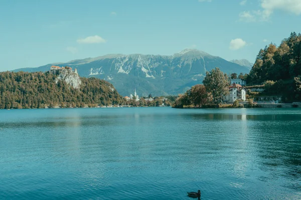 Dağlarla ve evlerle çevrili bir göl manzarası