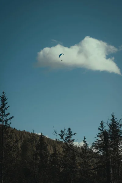 Gökyüzünde bir paraglider olan bir dağ manzarası