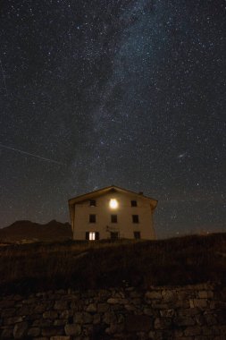 Night landscape with the Milky Way above a mountain house