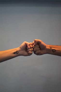 Kadın ve erkeğin elleri eşitliğin sembollerini yapıyor.