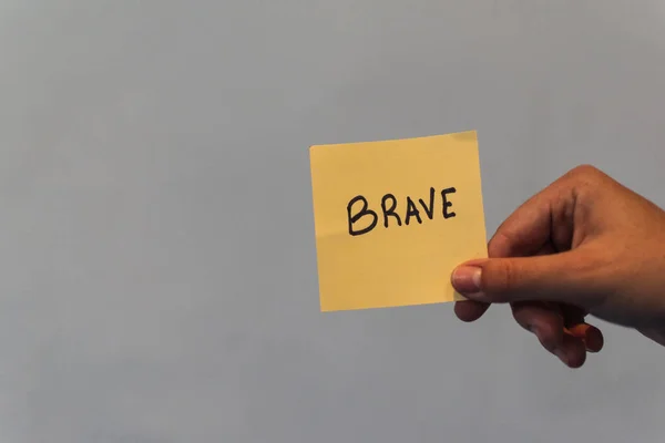 Sarı feminist posterleri gösteren bir el.