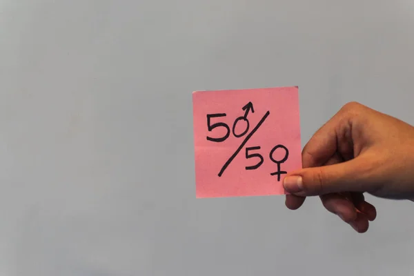 Pembe feminist posterleri gösteren bir el.