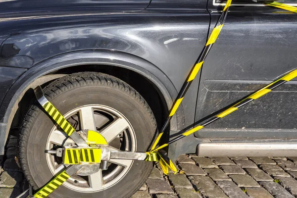 Araba tekerleği kilitlendi ve yasadışı park ihlali nedeniyle tekmelendi. Park kurallarını ihlal eden bir aracın tekerleğini engellemek için polis ekipmanı..