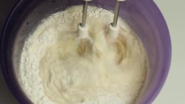 El elektrikli mikserle hamur yoğurmak. Elektrikli karıştırıcı kullanarak hamur çırpma işlemi.