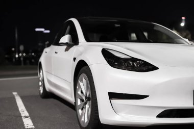 Tesla elektrikli arabası gece şehir parkına park edilmiş. Tesla Motors otomotiv şirketi Riga, Letonya - 22 Eylül 2021