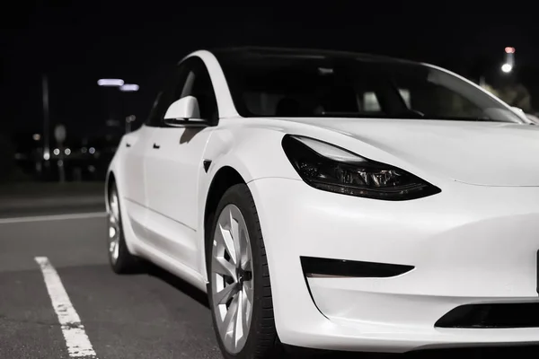 Tesla elektrikli arabası gece şehir parkına park edilmiş. Tesla Motors otomotiv şirketi Riga, Letonya - 22 Eylül 2021