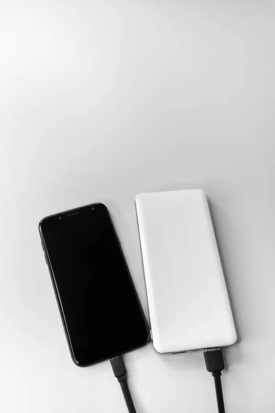 有線充電中のスマートフォンやパワーバンク — ストック写真