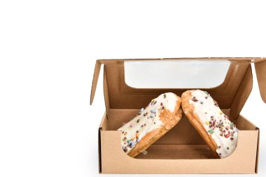 Beyaz arka planda, karton bir kutuda. Teslimattan sonra içinde tatlı pişmiş mallar olan tek kullanımlık bir kutu..