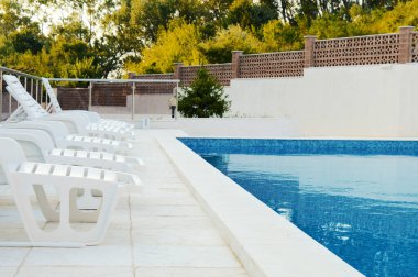 Dinlenmek ve tatilde dinlenmek için beyaz güneşli havuz.