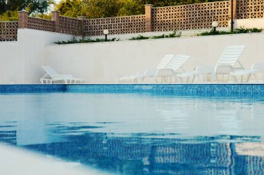 Tatil köyündeki yüzme havuzunda mavi berrak su.