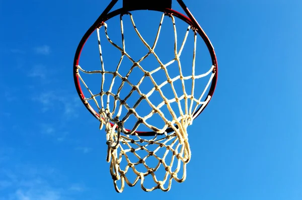 basketball net and hoop outdoors of sunny day against the blue sky, bottom view