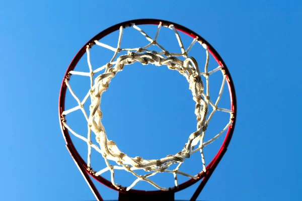 basketball net and hoop outdoors of sunny day against the blue sky, bottom view