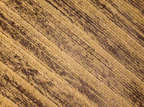 aerial view of harvested field in fall - texture with brown diagonal stripes for design and background