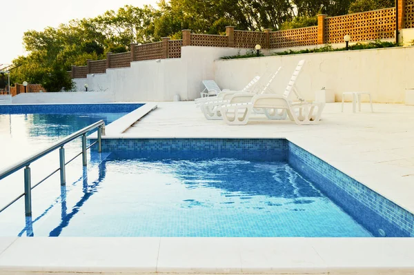 Güneşlenmek için bir yerin arka planında yüzme havuzu.