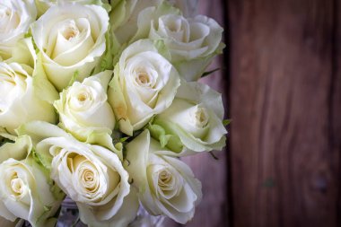 beautiful bouquet of white roses with wooden background.