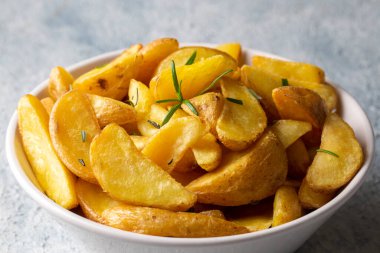 Kızarmış patates kamışı, otlar ve tabakta deniz tuzu, üst görünüm (Türk adı; elma dilim patatesi))