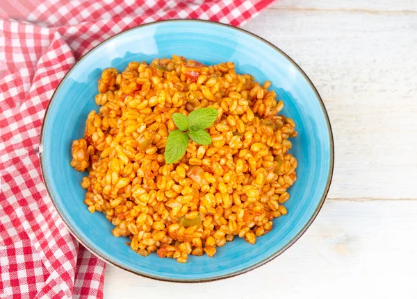 Tabakta domates sosu bulunan geleneksel Türk bulgur pilavı (Türkçe adı; meyhane pilavi)).