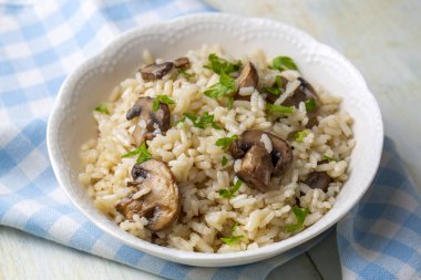risotto with mushrooms and parsley in white bowl