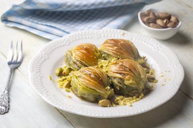 Yeşil şam fıstığı tozu ve tereyağı kremalı Türk Midye Baklava 'sı (Midye Baklava). İslami Ziyafetler Kavramı.