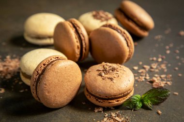 Mavi arka planda farklı renklerde badem kurabiyelerinin yakın çekimi. Mutfak ve yemek pişirme konsepti. Lezzetli renkli badem kurabiyeleri..