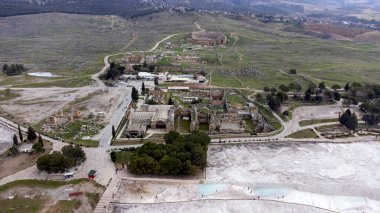 Pamukkale Travertines Türkiye, antik kaplıca kenti Hierapolis 'in beyaz kireçtaşı şehir silueti kalıntılarına tepeden bakıyor