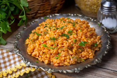 Tabağında domates sosu olan geleneksel Türk bulgur pilavı.