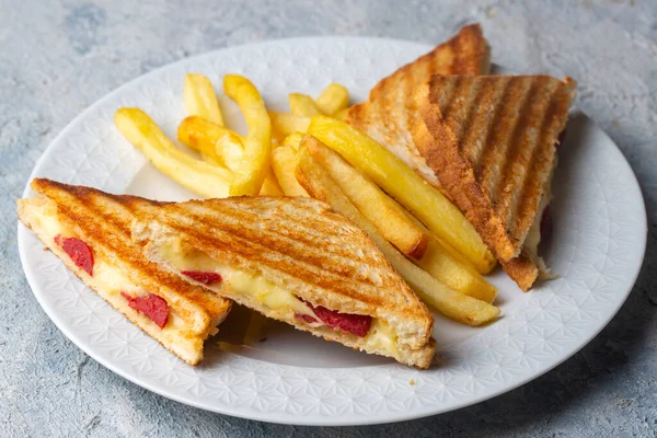 Türk tostu, çedar peyniri, sosis ve jambonla karıştırılmış tost, kızarmış patates (Türk adı Karisik tost))