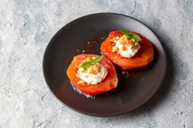 Geleneksel Türk usulü ayva tatlısı. Ayva, üzerine yumuşak şerbet dökülüp krema ve cevizle servis edilene kadar pişirilir. Türkiye 'nin en popüler tatlılarından biridir. (Ayva Tatlisi)