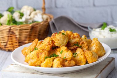 Hamur Karnabahar florets kızarmış malzemelerle gri bir beton masada siyah bir tabak üzerinde servis, yukarıdan görünümü, yakın çekim, flatlay, kopya alanı