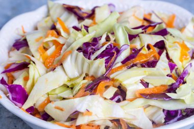 Mor lahanalı taze sebze salatası, beyaz lahana, marul, beyaz tabakta havuç.