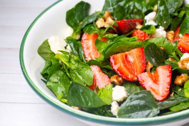 Summer Fruit Strawberry, cevizli ıspanak salatası, peynirli balzamik sirke, lahana. Tabakta. Sağlıklı gıda kavramları