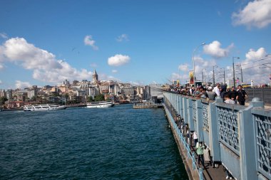 İstanbul - Türkiye, 18 Haziran 2022, Balıkçı, Galata Köprüsü Halkı ve arkadaki Galata Kulesi