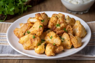 Hamur hamurunda kızartılmış Karnabahar çiçekleri, malzemelerle dolu gri beton bir masada, yukarıdan görünen, yakın çekim, düz alan, kopyalama alanı (Türkçe adı; karnabahar kizartmasi))