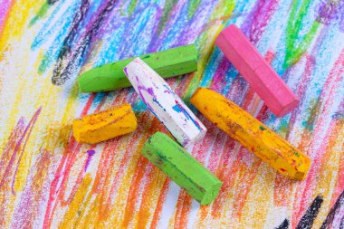 Colorful pastel crayons with painting background