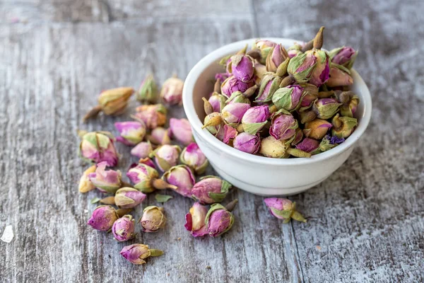 Dried small pink rose on the wooden background