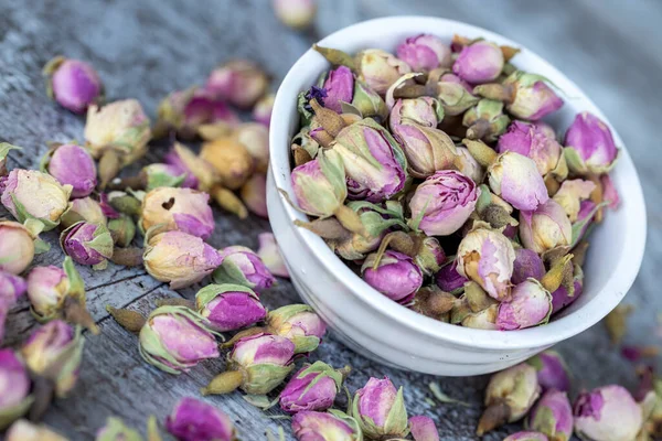 Dried small pink rose on the wooden background