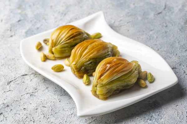 Yeşil şam fıstığı tozu ve tereyağı kremalı Türk Midye Baklava 'sı (Midye Baklava). İslami Ziyafetler Kavramı.