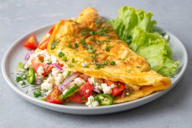 Omelet breakfast with cherry tomatoes and white feta cheese on white