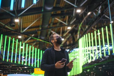 Moskova Sheremetyevo - 3 Ocak 2022: inek bir adamın portresi. Havaalanının kapısına yakın bir uçuşta maske takan bir turist. Coronavirus gribi virüsü seyahati