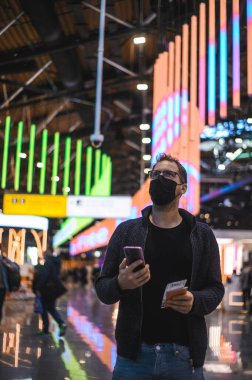 Moskova Sheremetyevo - 3 Ocak 2022: inek bir adamın portresi. Havaalanının kapısına yakın bir uçuşta maske takan bir turist. Coronavirus gribi virüsü seyahati