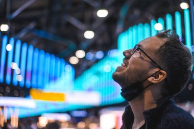 Moskova Sheremetyevo - 3 Ocak 2022: inek bir adamın portresi. Havaalanının kapısına yakın bir uçuşta maske takan bir turist. Coronavirus gribi virüsü seyahati