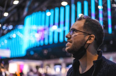 Moskova Sheremetyevo - 3 Ocak 2022: inek bir adamın portresi. Havaalanının kapısına yakın bir uçuşta maske takan bir turist. Coronavirus gribi virüsü seyahati