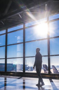 Moskova Sheremetyevo - 3 Ocak 2022: inek bir adamın portresi. Havaalanının kapısına yakın bir uçuşta maske takan bir turist. Coronavirus gribi virüsü seyahati