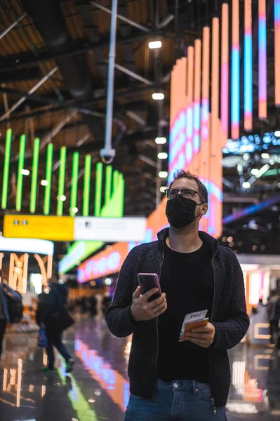 Moskova Sheremetyevo - 3 Ocak 2022: inek bir adamın portresi. Havaalanının kapısına yakın bir uçuşta maske takan bir turist. Coronavirus gribi virüsü seyahati