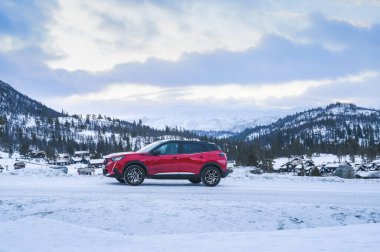 Rauland, Norveç - 14 Ocak 2022: Kırmızı elektrikli otomobil Peugeot e-2008 GT yeni bir SUV elektrikli otomobil.. 